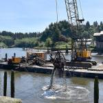 DAN HAMMOCK | GRAYS HARBOR NEWS GROUP                                 A barge and crane, secured by a tug, hauled pieces of the Lady Grace out of the Hoquiam River Wednesday.