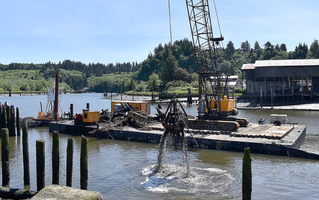 DAN HAMMOCK | GRAYS HARBOR NEWS GROUP                                 A barge and crane, secured by a tug, hauled pieces of the Lady Grace out of the Hoquiam River Wednesday.