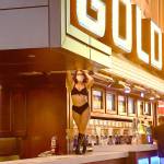 Clad in a bikini and face mask, a dancing bartender returns to work at the Golden Gate Casino in downtown Las Vegas on Thursday. (Christopher Reynolds/Los Angeles Times)