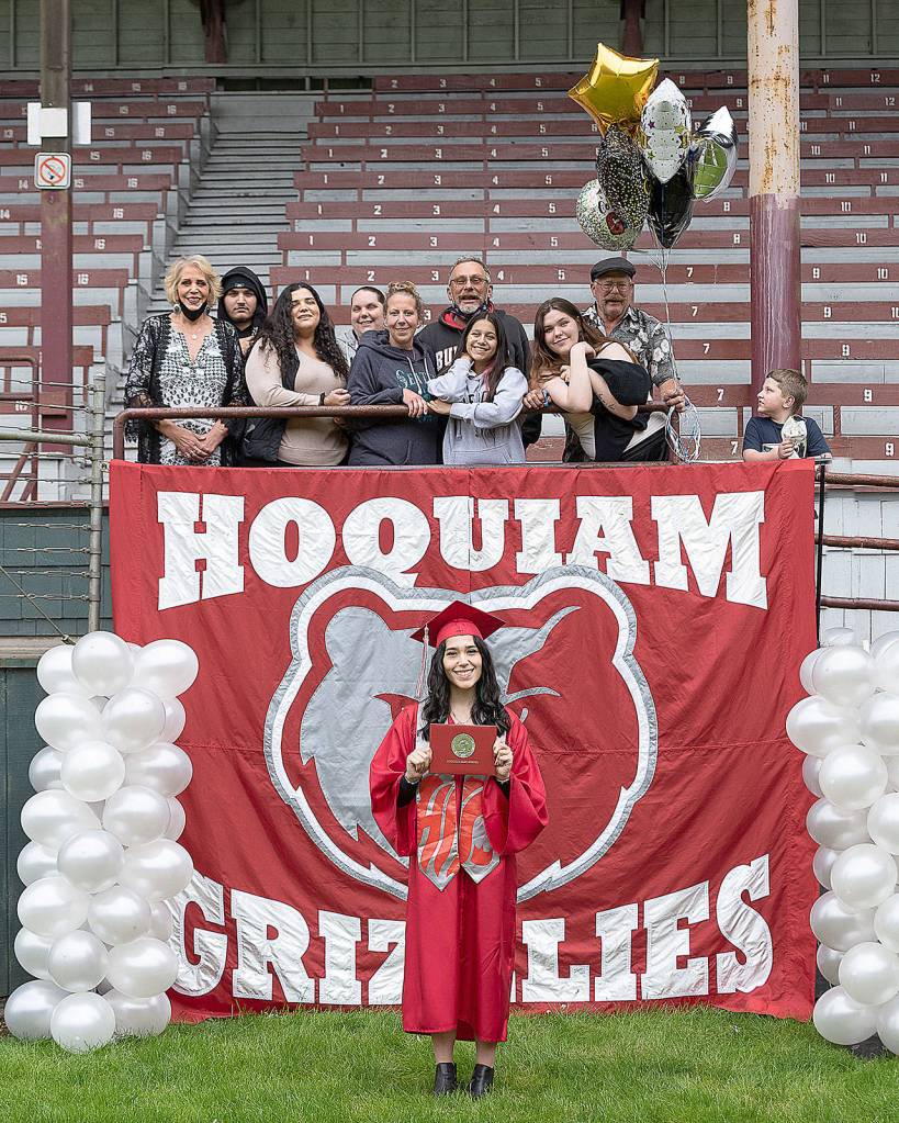 PAMELA PELAN PHOTOGRAPHY                                 Graduating Hoquiam High School seniors were allowed to bring immediate family members to watch them pick up their diplomas at Olympic Stadium on Monday. Here Kylee Estrada poses with her family after picking up her diploma.