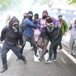 Protesters run from flashbangs in downtown Seattle on May 31 during protests over the death of George Floyd in Minneapolis. (Ken Lambert/Seattle Times)