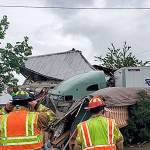 COURTESY GRAYS HARBOR FIRE DISTRICT 5                                 Emergency personnel assess the damage after a two-semi wreck on State Route 12 in Malone Friday afternoon sent one rig through a fence and into two homes and a residential travel trailer.