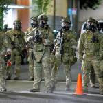 Federal officers hold their line at SW Third and Taylor streets early Saturday morning after a long night of protests in downtown Portland. (Dave Killen | The Oregonian)