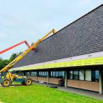 COURTESY PHOTO                                 Replacement of the old cedar shakes at Hoquiam High School is underway. Here you can see the new composite shakes going up, which match the look of the Mansard-style roof and will hold up to Hoquiam weather.