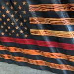 Kat Bryant | Grays Harbor News Group                                This wavy wooden flag, created by Cosmopolis artist Nick Bailey, includes a red stripe signifying support for firefighters. As of Wednesday morning, SusanMarie had received an online bid of $250 for it.
