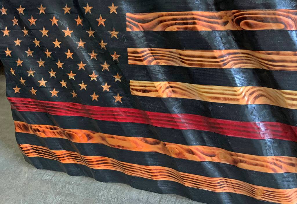 Kat Bryant | Grays Harbor News Group                                This wavy wooden flag, created by Cosmopolis artist Nick Bailey, includes a red stripe signifying support for firefighters. As of Wednesday morning, SusanMarie had received an online bid of $250 for it.