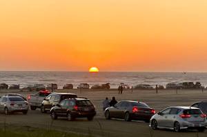 Robert Smyth photo                                Vehicles crowd the beach at Ocean Shores to view the sunset on Saturday.
