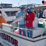 DAN HAMMOCK | GRAYS HARBOR NEWS GROUP                                 Delaney Kramer of Spokane caught this 25-plus-pound Chinook Aug. 13 from the charter boat Predator. Captain Derek Gochanour, holding the salmon, immediately after this photo hustled Kramer and her fish to the Westport Charterboat Association derby booth; it wound up being the daily derby winner.