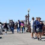 DAN HAMMOCK | GRAYS HARBOR NEWS GROUP                                 People walk the boardwalk at the Westport Marina Aug. 13. Visitors wore masks when not socially distanced, dropping them only for bites of ice cream.