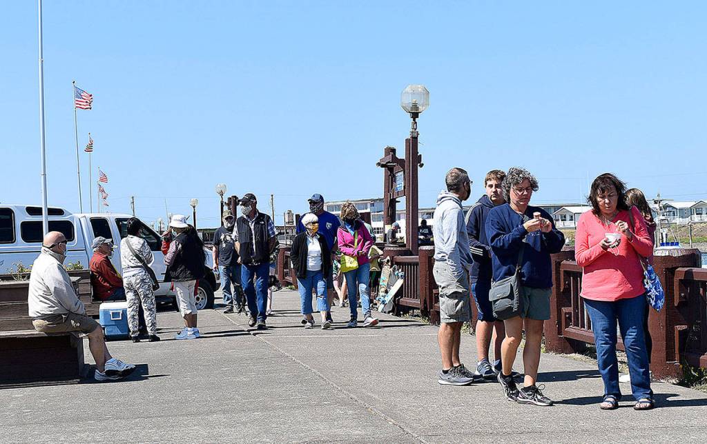 DAN HAMMOCK | GRAYS HARBOR NEWS GROUP                                 People walk the boardwalk at the Westport Marina Aug. 13. Visitors wore masks when not socially distanced, dropping them only for bites of ice cream.