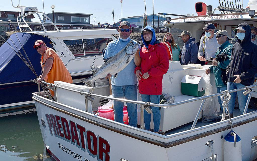 DAN HAMMOCK | GRAYS HARBOR NEWS GROUP                                 Delaney Kramer of Spokane caught this 25-plus-pound Chinook Aug. 13 from the charter boat Predator. Captain Derek Gochanour, holding the salmon, immediately after this photo hustled Kramer and her fish to the Westport Charterboat Association derby booth; it wound up being the daily derby winner.