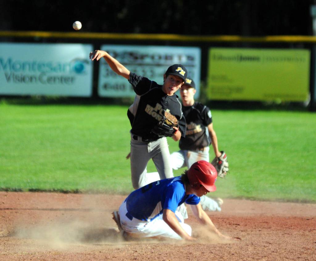 Pub Monte second baseman Toren Crites attempts to turn a double play after shortstop Bode Poler, background, made a spectacular diving stop during the a 12-3 Little League championship loss to the Peterson Rock Drillers on Saturday at Vessey Field in Montesano. The Drillers Tyler Johansen slides into second on the play. (Ryan Sparks | Grays Harbor News Group)