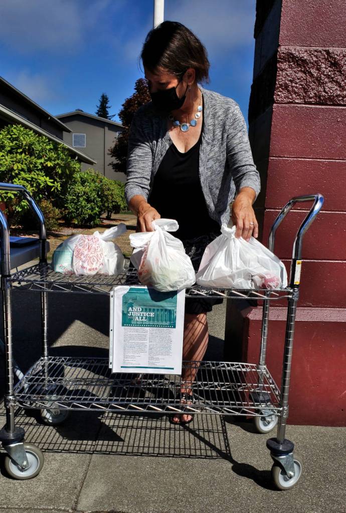 Montesano School District employee Lise Wood organizes lunches during the first day of school on Wednesday in Montesano. Wood approximates that 30 lunches were handed out in the first half hour and expects that number to increase as the school year advances. Meals are available for delivery and pick-up from 11 a.m. to 1 p.m. (Ryan Sparks | The Daily World)