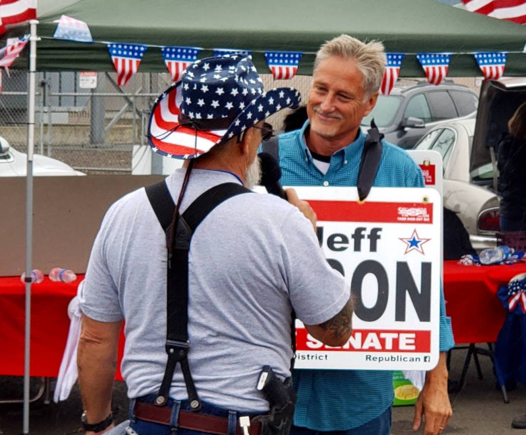 Jeff Wilson, right, prepares to speak to the crowd at the Harbor Freedom Rally on Saturday in Aberdeen. Wilson is running for the 19th District state senate seat. (Ryan Sparks | The Daily World)