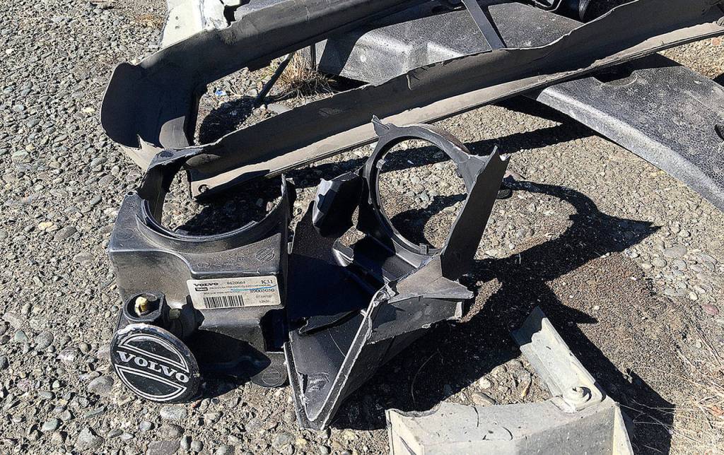 DAN HAMMOCK | THE DAILY WORLD Various Volvo remains after an early morning one-car wreck on State Street that sheared off two city light poles Wednesday.