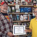 Aberdeen Lions member Greg Johnstone presents a certificates of appreciation to Gregory Zschomler of Harbor Books.