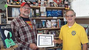 Aberdeen Lions member Greg Johnstone presents a certificates of appreciation to Gregory Zschomler of Harbor Books.