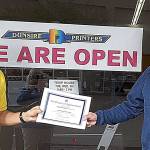 Aberdeen Lions member Greg Johnstone presents a certificates of appreciation to Sandy Dunsire of Dunsire Printers.