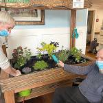 Darrald Dewald, left and Bob Kloempken work in one of the indoor gardens at Pacific Care and Rehabilitation Center.