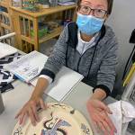 Kat Bryant | The Daily World 
Evie Cheung especially enjoys decorating clay pieces. She painted this scene on a plate created by another artisan.