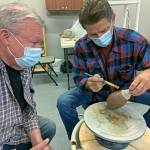 Gary Ganz, right, shows fellow guild member Ken Slaughter the ancient art of Terra Sigillata clay painting. (Kat Bryant | The Daily World)
