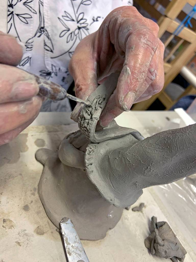 Kat Bryant | The Daily World 
Melanie Knight demonstrates how to fuse two pieces of soft clay together: She roughs it up by cross-hatching the areas that will be joined.