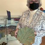 Kat Bryant | The Daily World 
Melanie Knight shows a plate she created with the imprint of a natural leaf from her garden. Its one of many pieces displayed for sale in the gallery.