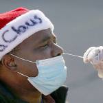 Anthony Harvin wears a Santa hat as he receives a coronavirus test from Dante Terracciano of Philly Fighting COVID at Vine Memorial Baptist Church in West Philadelphia on Saturday. Staff from Philly Fighting COVID and the Children's Hospital of Philadelphia offered free testing organized by the traveling Community-Accessible Testing & Education (CATE) program, which offers testing at different sites across Pennsylvania. (Tim Tai/The Philadelphia Inquirer/TNS)