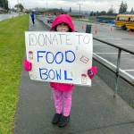 Elma fifth-grader Abigail Henry holds up a sign promoting donating to the Elma Food & Money Drive that took place Nov. 12-24. The event raised over $17,000 and 6,000 pounds of food benefitting food banks in Elma, McCleary and Malone. (Submitted photo)