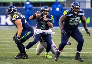 Bettina Hansen/The Seattle Times 
Seahawk quarterback Russel Wilson is sacked during the second half Sunday. It was one of five sacks allowed by Seattle in a 17-12 loss to the New York Giants.