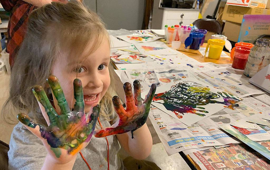 Kat Bryant | The Daily World 
Mae Gambee, 4, did some freestyle finger-painting on Saturday in addition to decorating ornaments made from sand dollars and other materials provided by the Cosi Art Center. She was there with her mom, Sarah Gambee, and baby brother Grant.