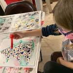 Kat Bryant | The Daily World 
Aubriel Munoz, 8, used a Christmas tree template and dotted it with multicolored ornaments Saturday at the Cosi Art Center. She was there with her dad, Jonathan Munoz.