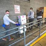 Pool Photo
UWMC Montlake campus Pharmacy Administration Resident Derek Pohlmeyer, left, and UWMC Pharmacy Director Michael Alwan transport a box containing the Pfizer coronavirus vaccines toward a waiting vehicle headed to the UW Medicines other hospital campuses on Monday morning. These are among the first to be distributed in Washington state.