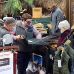 Waugh's Men's Store owner Daniel Crocker, middle, helps customers on Thursday in Aberdeen. (Ryan Sparks | The Daily World)