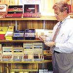 Waughs Mens & Womens Apparels former owner Ray Ericks holds a Monte Cristo cigar in one of the specialty rooms in his store in downtown Aberdeen. (Daily World file photo)