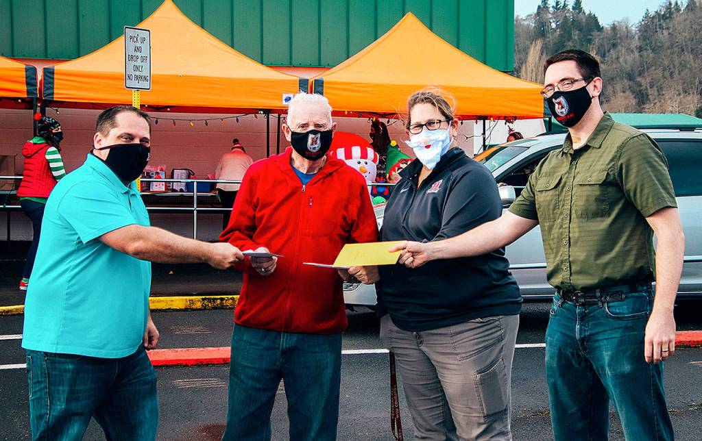 COURTESY PHOTO 
The Hoquiam elementary administrative team hands Joe Cornell a donation for his organization, Making a Difference for Grays Harbor Kids. Pictured from left are Brandon Winkelman, Cornell, Laurie Gordon, and Kent Nixon.