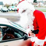 Kailyn Jackson and Sara Zillyette with Santa at Emerson Elementarys drive through Santa event Tuesday. COURTESY PHOTO