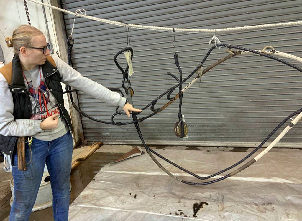 Crew member Brooke Gipson explains the importance of tarring the various components for waterproofing. (Kat Bryant | The Daily World)