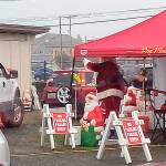Santa Claus waves to children in slowly passing cars during the drive-through visit hosted by the Hoquiam Elks in their back parking lot last Saturday. (Photos by David Haerle)