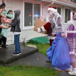 DAN HAMMOCK | THE DAILY WORLD 
First stop for the caravan of Hoquiam fire and police vehicles was Grizzly Lane. Donations from local citizens and groups allowed Santa and Mrs. Claus to deliver gifts not only to the family selected from the police department giving tree, but others in the neighborhood.