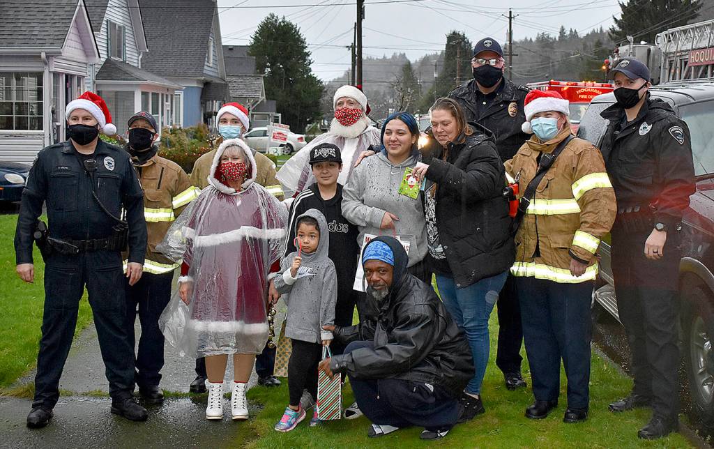 DAN HAMMOCK | THE DAILY WORLD 
Santa, Mrs. Claus and elves from the Hoquiam police and fire departments delivered gifts to this family on Chenault Avenue Monday.
