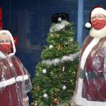 DAN HAMMOCK | THE DAILY WORLD 
Santa and Mrs. Claus  BJ and Neal Fisher  stand beside the Hoquiam Police Department giving tree before heading out to deliver toys to families throughout the town. Below, Mrs. Claus and elves from the Hoquiam police and fire departments delivered gifts to this family on Chenault Avenue on Monday.