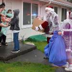 DAN HAMMOCK | THE DAILY WORLD 
First stop for the caravan of Hoquiam fire and police vehicles was Grizzly Lane. Donations from local citizens and groups allowed Santa and Mrs. Claus to deliver gifts not only to the family selected from the police department giving tree, but others in the neighborhood.