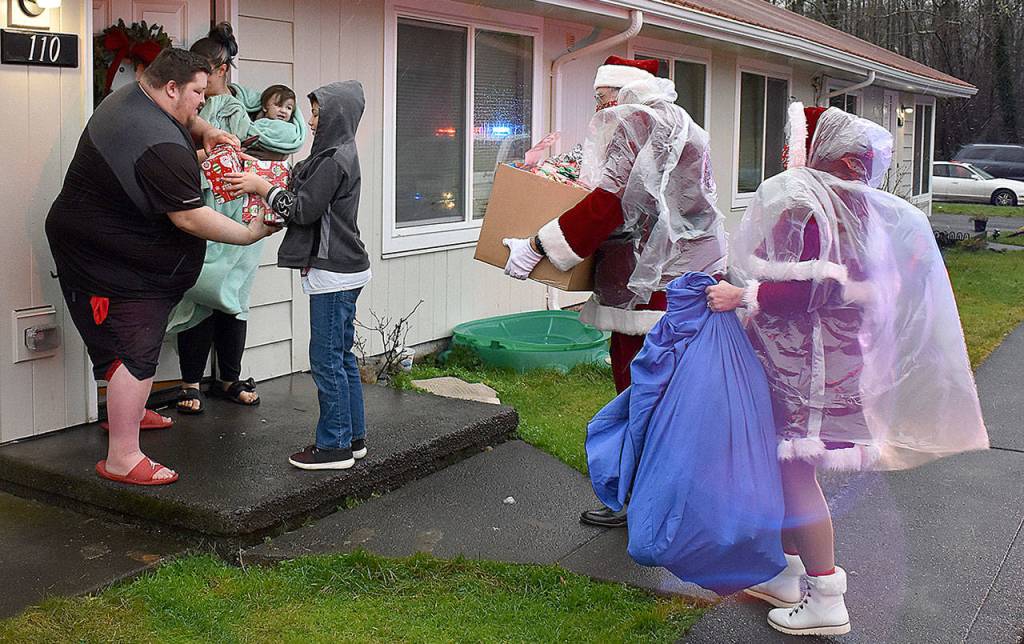 DAN HAMMOCK | THE DAILY WORLD 
First stop for the caravan of Hoquiam fire and police vehicles was Grizzly Lane. Donations from local citizens and groups allowed Santa and Mrs. Claus to deliver gifts not only to the family selected from the police department giving tree, but others in the neighborhood.