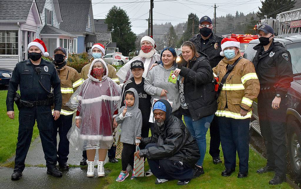DAN HAMMOCK | THE DAILY WORLD 
Santa, Mrs. Claus and elves from the Hoquiam police and fire departments delivered gifts to this family on Chenault Avenue Monday.