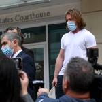 Tiffany Tompkins/Bradenton Herald 
Adam Johnson, right, emerges from the Tampa Federal Courthouse after an appearance Monday, wearing an ankle monitor.