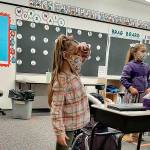 COURTESY PHOTO
Cosompolis kindergartners Ellie Adams-Bridges, left, and Madison Plummer practice standing in their social distancing spots during instruction, as Superintendent/Principal Cherie Patterson put it, so they can get their wiggles out.