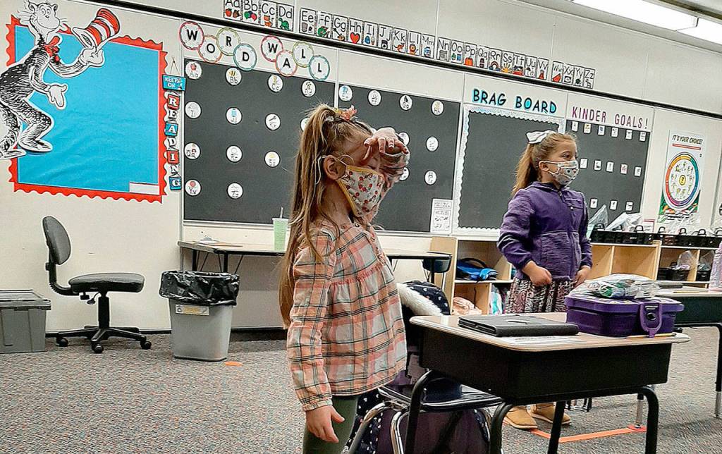 COURTESY PHOTO
Cosompolis kindergartners Ellie Adams-Bridges, left, and Madison Plummer practice standing in their social distancing spots during instruction, as Superintendent/Principal Cherie Patterson put it, so they can get their wiggles out.