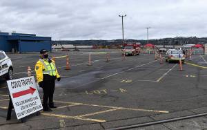 DAN HAMMOCK | THE DAILY WORLD 
After checking in at the guard shack outside the countys mass vaccination site, vehicles are directed to a second checkpoint, where people are asked if they have pre-existing conditions that would require a longer hold time after the vaccination is delivered.