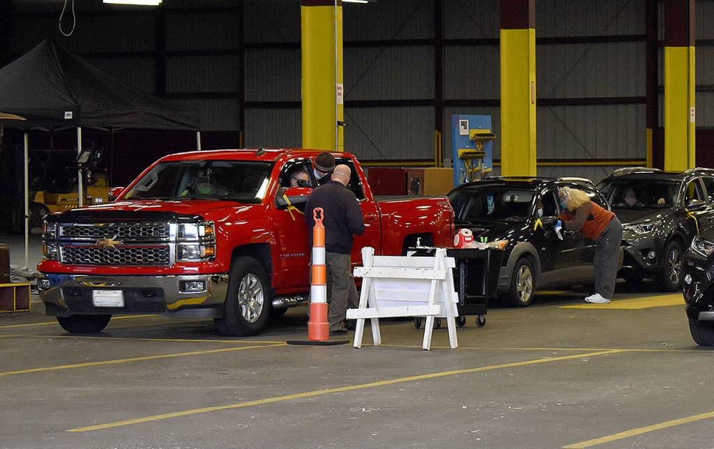 DAN HAMMOCK | THE DAILY WORLD 
After receiving a vaccination, vehicles were directed to a holding area, where people were observed for 15-30 minutes for any adverse reactions to the vaccine.
